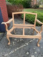 Front view of the solid wood loveseat frame showing overall structure and build.