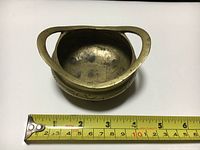 Top-down view showing the inner bowl of the tripod and scale with measuring tape indicating approximately 4 inches width.