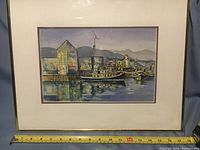 Original watercolor painting of a harbor scene featuring boats, buildings, mountains, signed by Laurie Thompson visible in lower left.