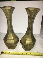 Pair of hexagonal solid copper Chinese vases with hand-carved designs and ruler showing approximately 10 inches in height.