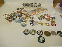 Group photo of assorted vintage 1990s pogs spread out on a surface showing various colorful designs and motifs.
