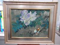 Full view of the framed painting showing two birds, flowers, leaves, and a textured background.