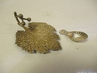Photo showing both items: the Indian engraved silver leaf tray and the Irish sterling silver shell-shaped spoon