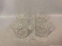 Four vintage Waterford crystal glasses arranged in a group showing their overall shape and cut pattern details.