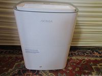 Front view of NOMA dehumidifier showing white plastic body with NOMA logo.