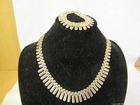 Necklace and bracelet displayed on black bust