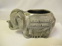Side angle showing engraved text 'BENGAL LOUNGE EMPRESS HOTEL' on elephant body and opening on top.