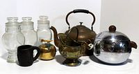 Front view showing all 8 items including the glass cannisters, copper kettle, penguin ice bucket, coal scuttle, black mug, and brass apple with lid.
