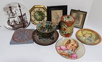 Group shot of various decorative vintage items including plates, stained glass, tin canister, and tiles
