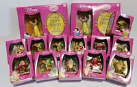 Front view of all boxed Disney Snow White and Seven Dwarfs figurines including Snow White and all dwarfs, showing the packaging and figurines inside
