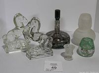 Full view of the lot showing all six items arranged on white background including horse bookends, silver overlay decanter, toothpick holder, frosted glass piece and two small glass vases.