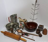Full lot displayed showing all items including rolling pin, sifter, serving utensils, wooden bowl, copper ladle, wooden horse figurine, tin molds, mortar and pestle, and metal drying rack.