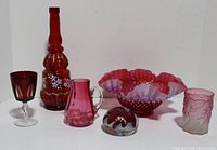 Group photo of all vintage red art glass items in lot, showing each distinct piece including the bowl, creamer, tumbler, decanter, and paperweight.