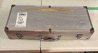 Closed aluminum case with label indicating BBQ tools inside and damage to lining.