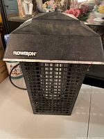 Front view of black Flowtron bug zapper device showing main grid and logo on textured sloped top cover.