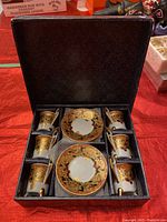 Porcelain espresso set with six cups and two saucers in original box, top view.