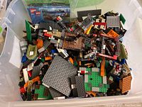 Overhead view of bin filled with assorted LEGO pieces including plates, bricks, and specialty parts.