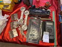 General overview photo showing heavy duty spring compressor, wrenches, multimeter, vice grips, lamp heads and door hinges