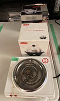 Photo of HomeMax single electric burner and Dash rapid egg cooker boxes, showing the burner top and box labels