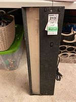 Front view of the rectangular black metal shop light with translucent center diffuser and control switch.