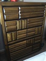 Front view of the wooden dresser showing all five drawers with a textured pattern on the front panels