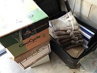 Photo showing multiple boxes and a plastic bin containing wrapped chopsticks and other boxed items.