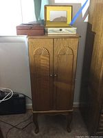 Full view of wooden jewelry cabinet with two jewelry boxes on top