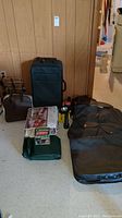 Full view of all luggage items, travel gear, bowling ball and bag, air beds, and boxes on floor against wall