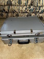 Closed silver aluminum carrying case on carpet