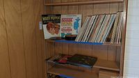 Photo of vinyl records boxed and standing upright on shelf showing some album titles including Mary Poppins, Bossa Nova Samba.