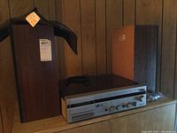 Full view of Panasonic stereo model SGV03 with two speakers and protective cover on top, showing stereo unit front panel and wood veneer on speakers