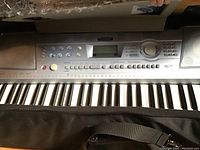 Yamaha PAR-292 keyboard with visible keys and control panel buttons, partially inside black carrying bag
