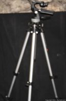 Image showing BOGIN camera tripod with telescoping legs and pan-tilt head against black background.
