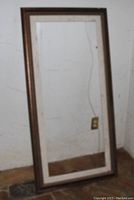 Photo of one tall wooden frame resting against a wall showing size and wood finish