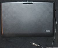 Closed view of a black textured portable DVD player with a visible power cable ending in a car cigarette lighter plug.