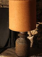 Full view of the rustic rope wrapped table lamp in a low-lit setting.