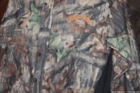Close-up of heavy weight camo jacket with button closures and Scent Loc logo embroidery