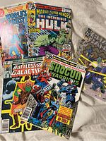 Photo showing 4 vintage comic books - World's Finest, The Incredible Hulk, Battlestar Galactica, and Shogun Warriors with detailed cover art.