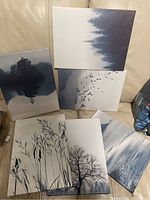 Six unframed IKEA wall pictures with nature scenes in muted color palette arranged on cream background.