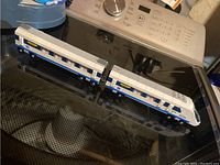 Two-piece Lego train set on a stove top, showcasing the engine and passenger car connected