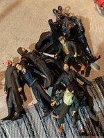 Top-down photo of seven Lord of the Rings action figures arranged on the floor, showing various characters in costume and gear.