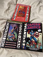 Photo showing three Marvel Essential comic books: two Spider-Man editions and one Captain America Vol 1.
