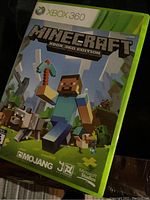 Minecraft Xbox 360 Edition game in green Xbox 360 case showing front cover artwork with main character and game creatures.