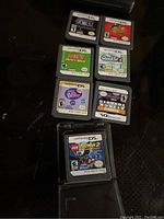 Photo showing seven Nintendo DS loose game cartridges, identifiable by label titles and ratings.