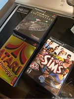 Photo of three PlayStation 2 game cases: Atari Anthology, Star Trek Encounters, The Sims