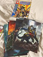 Photo of eleven White Dwarf magazines arranged on a fabric background, showing sample cover art including fantasy and sci-fi characters.