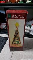 Photo of boxed 16-inch glass candle holder shaped like a holiday tree with star top, front packaging view.