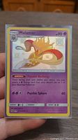 Close-up of the Malamar Pokémon card showing its holographic surface, ability, attack, and set details.