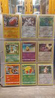 Photo of 9 Pokemon cards in plastic sleeve: Charizard, Darkrai, Bulbasaur, Beedrill, Pidgey, Ekans, Magmar, Bellsprout, Spinda.