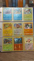 Nine Pokemon cards in clear plastic binder sleeves showing various Pokemon characters and types.